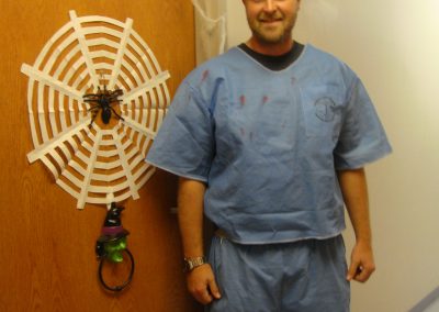 Picture of Corey Lunde dressed as doctor next to door with spider web