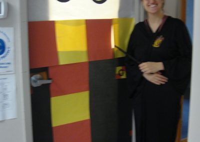Picture of CT staff member Erica Simons dressed as Harry Potter next to door decorated like Harry Potter