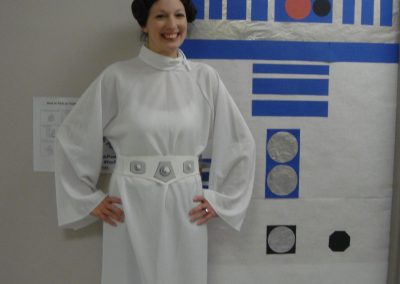 Picture of CT Staff member Leah Downey dressed as princess Leia next to door decorated as R2-D2