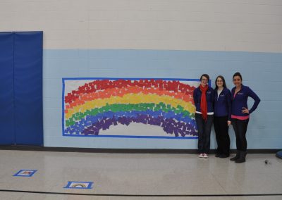 CT Staff members Leah, Jen, and Kristin in front of rainbow project